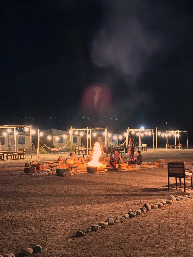 Guests gathered around the campfire beneath a starlit desert sky
