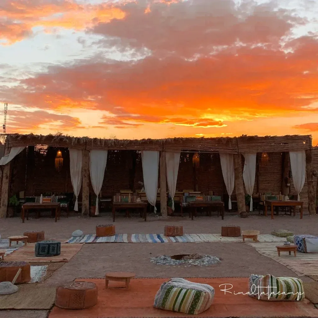 Rimal Tata Camp at sunset with draped pavilions and desert rugs