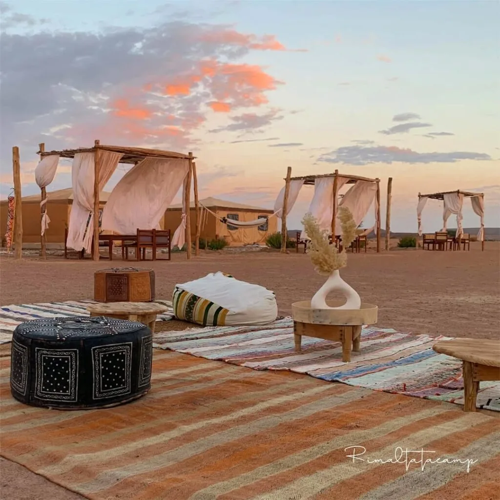 Sunset lounge with poufs, rugs and low tables at the camp