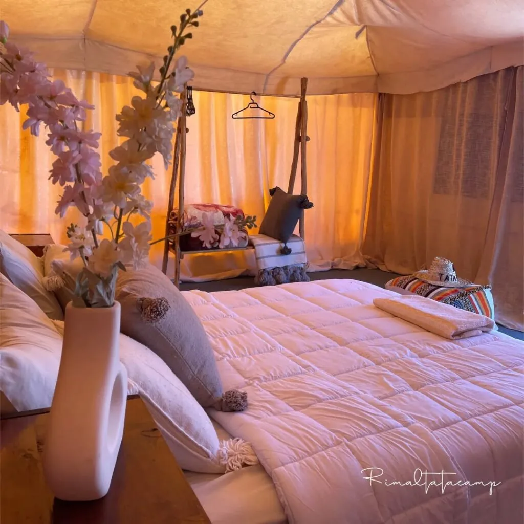 Tent interior with fresh flowers and soft bedding